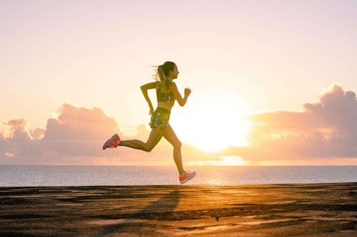 Donna che corre con abbigliamento Asics