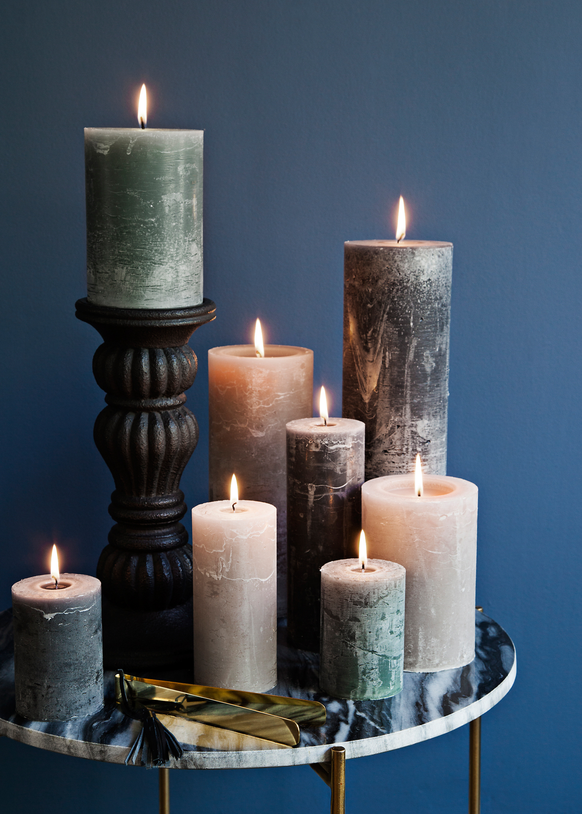 collection of lit candles on marble table  