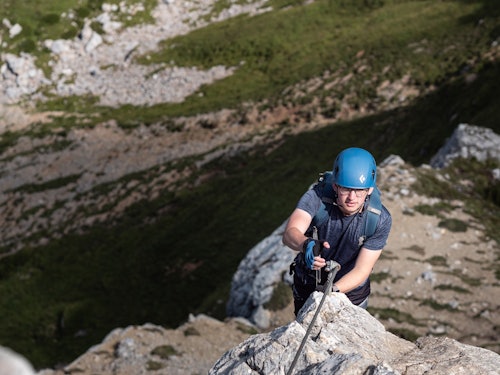 Mann in steilem Klettersteig.