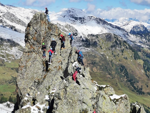 Gruppe Bergsteiger am Klettersteig auf einer Felszacke