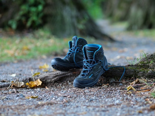 Kinder-Wanderschuhe stehen auf einer Wurzel im Wald