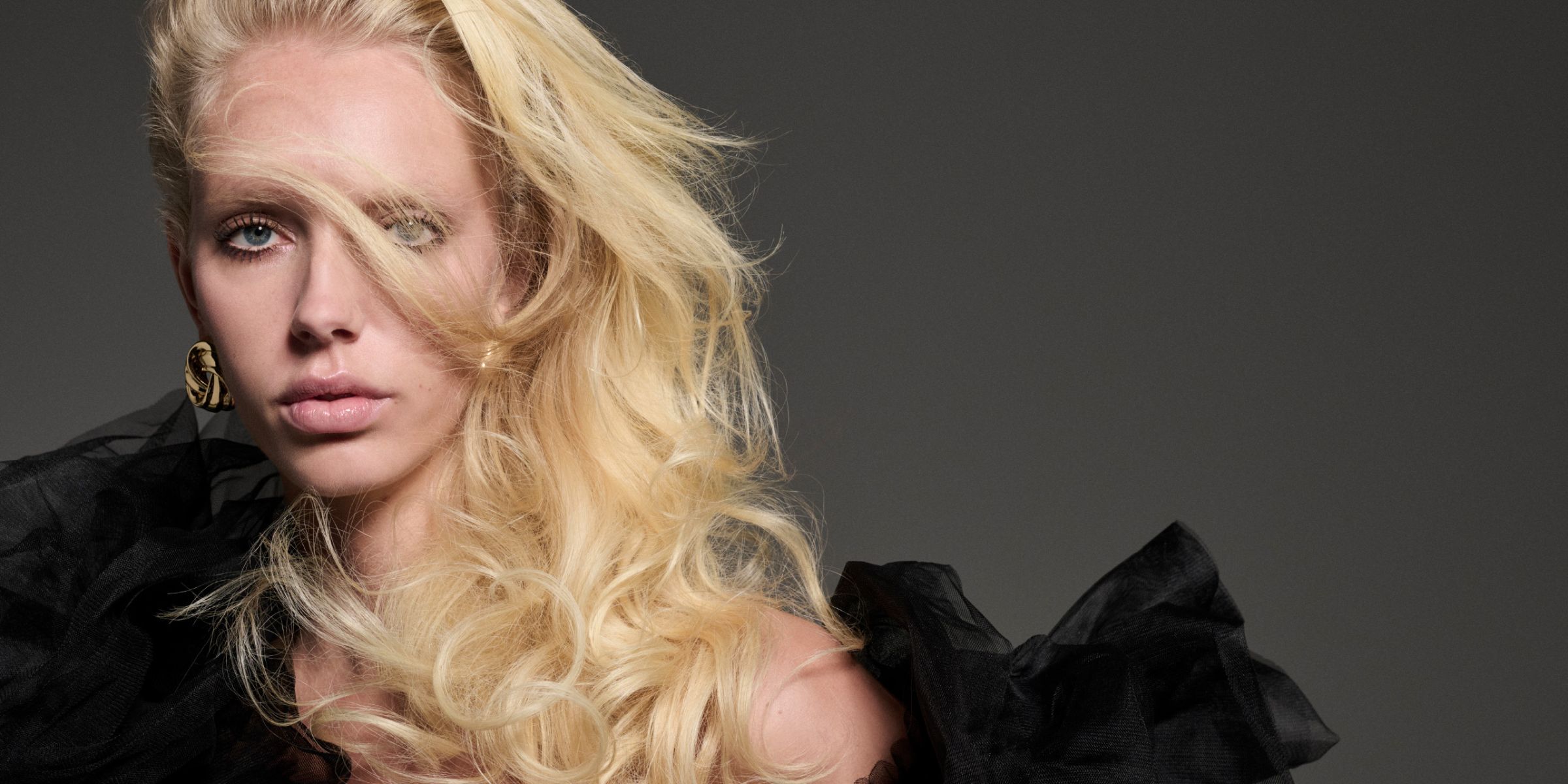 Woman with long volumous hair and festive-chic clothing