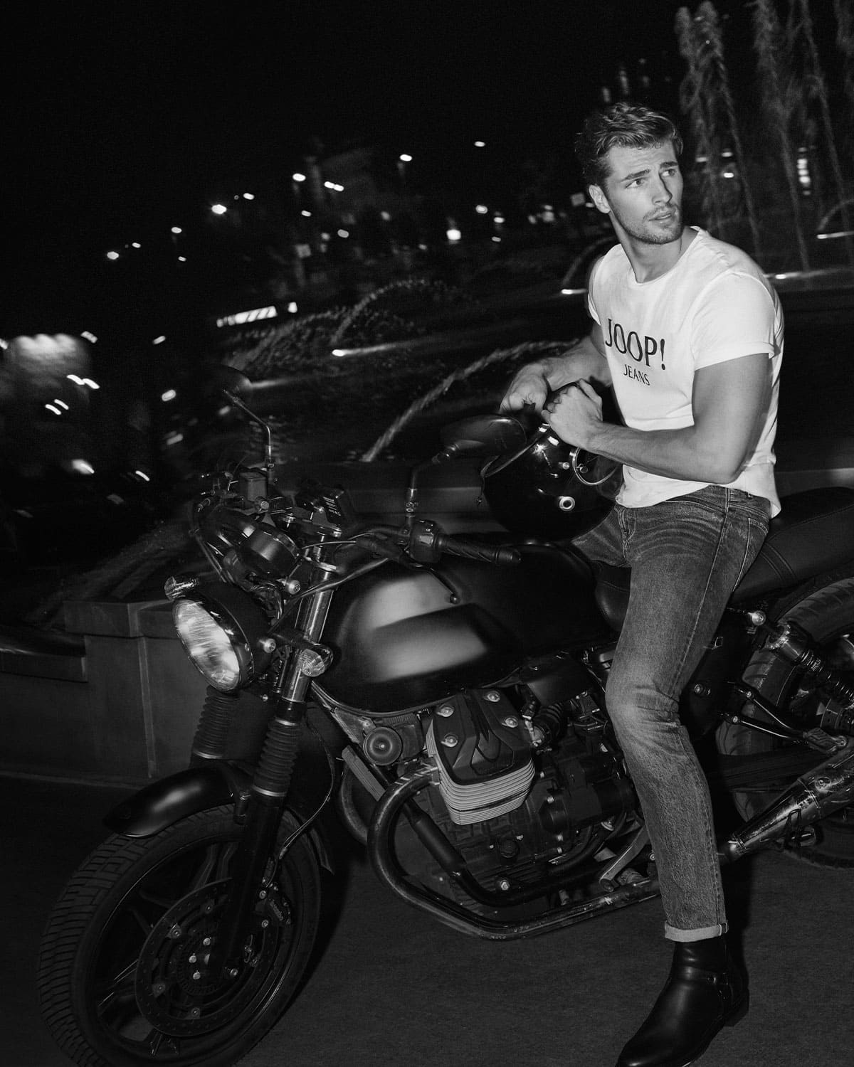 JOOP! jeans gentleman sits on a motorcycle with a white JOOP! JEANS tshirt and jeans all in black and white