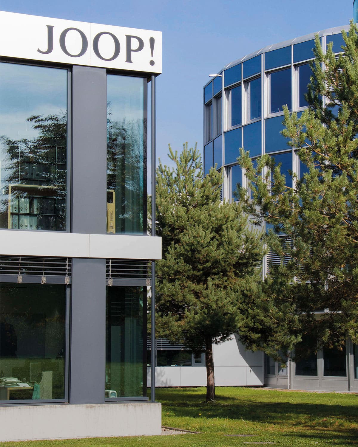 Holy Fashion Group a modern building with joop lettering next to two trees