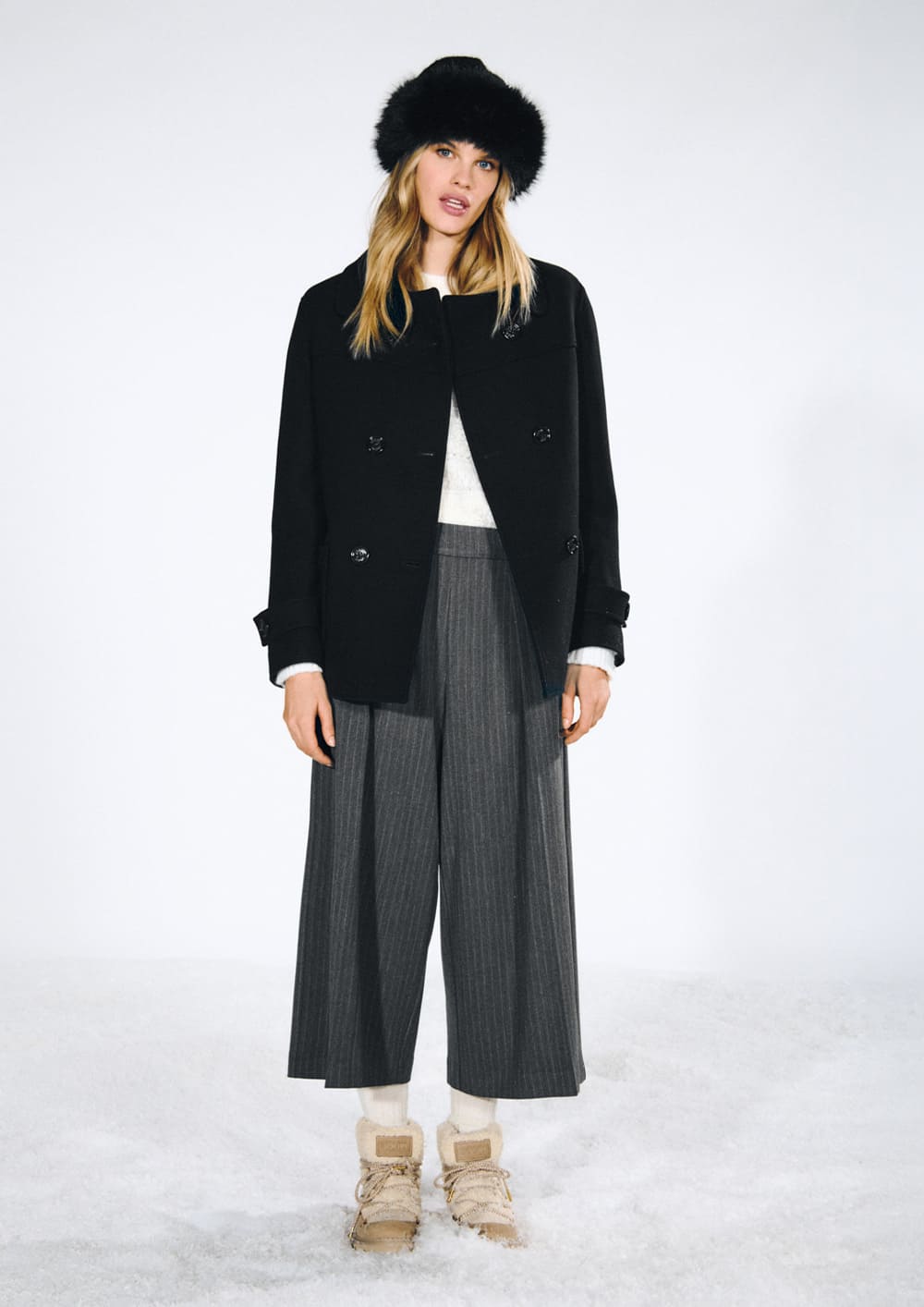 Woman in a black double-breasted short jacket with gray culottes