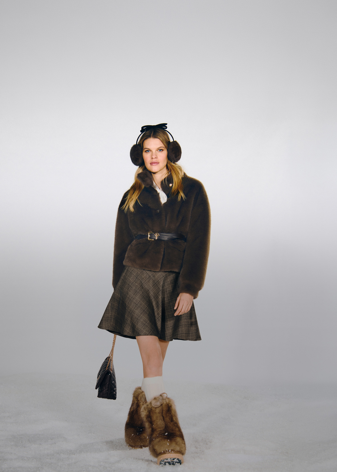 Woman wearing a brown Joop faux fur short jacket with a brown plaid skirt