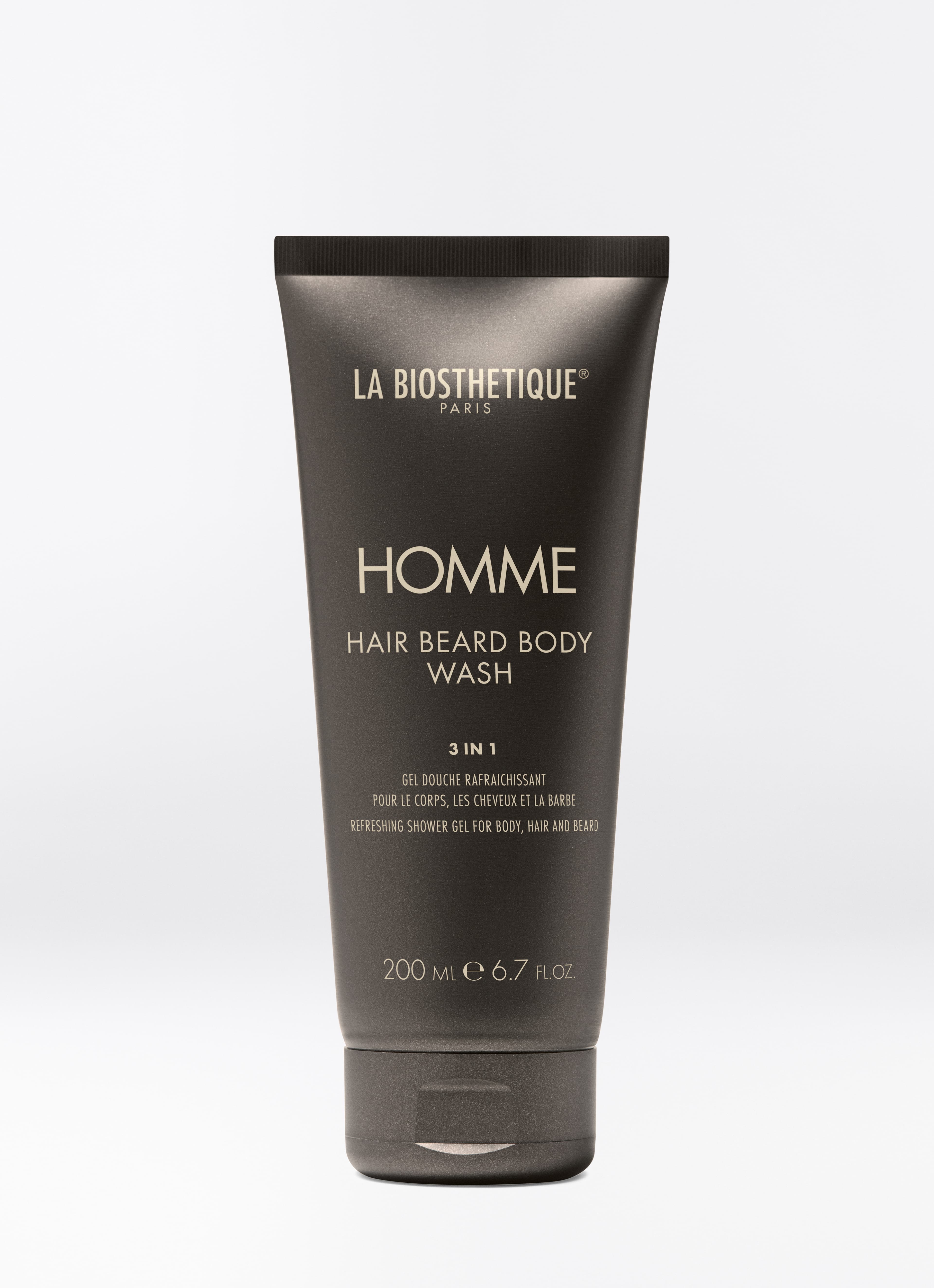 Dunkelbraune Tube des Homme Hair Beard Body Wash auf hellgrauem Hintergrund.