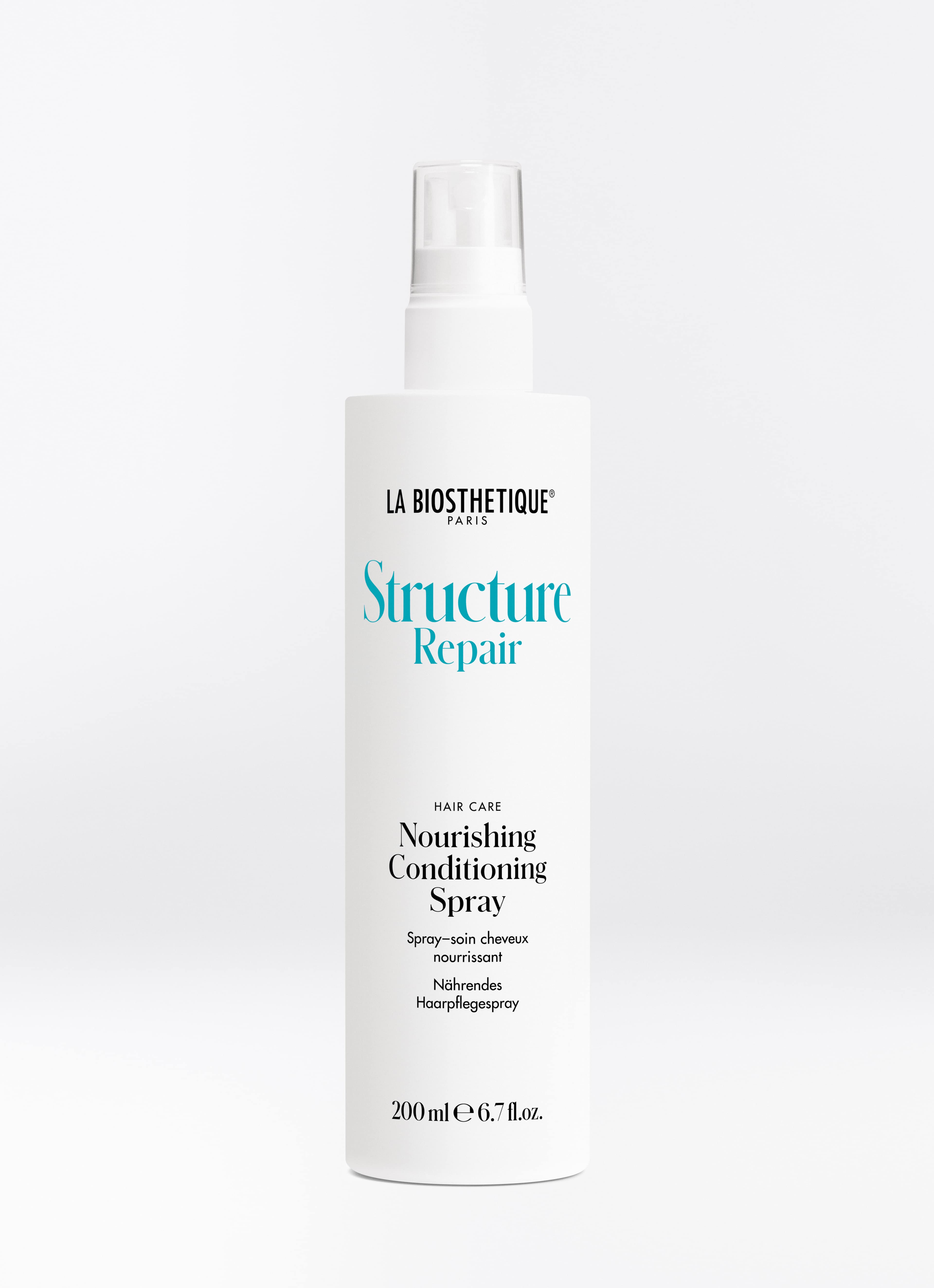 Weiße Sprühflasche des Structure Repair Nourishing Conditioning Spray auf helllgrauem Hintergrund.